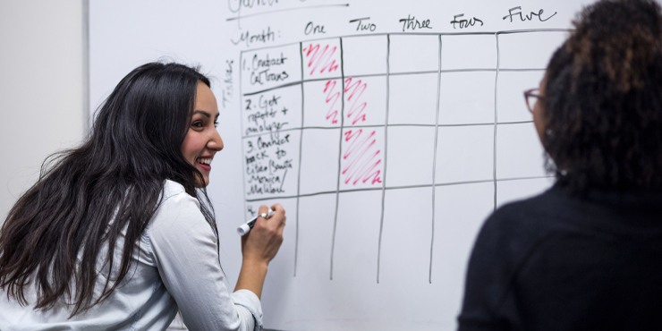 Students writing on the white board - Pepperdine University