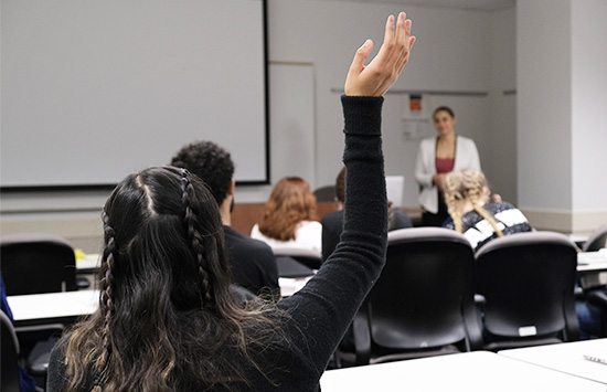 Student raising their hand in a classroom 