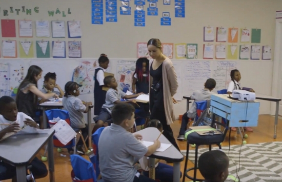 Hattie Mitchell walking around a classroom with young kids