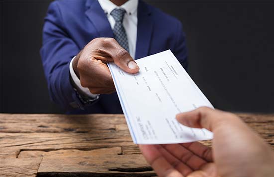 Business person handing over a paycheck