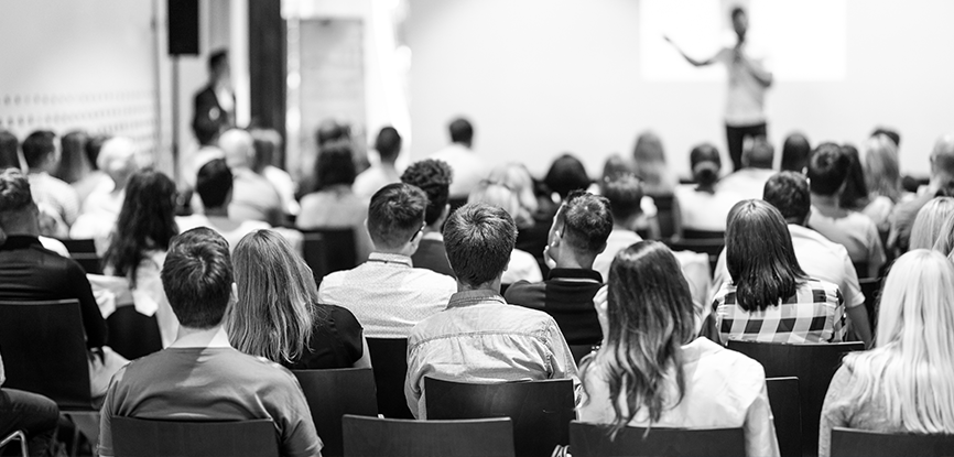 Room with people listening to lecture