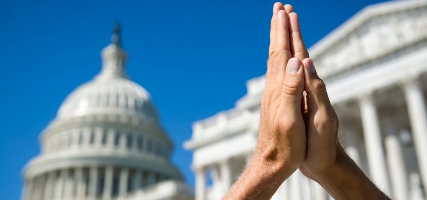 Praying hands in from of the US Capitol