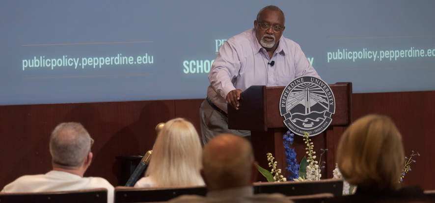 Glenn Loury at the podium giving a lecture 