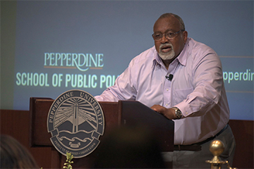 Glenn Loury at the podium giving a lecture 