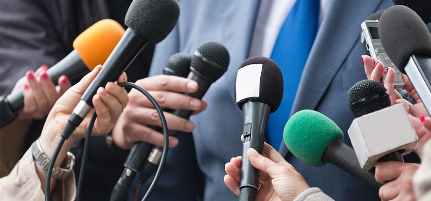 People holding news microphones to person