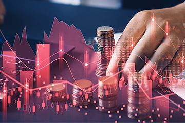 Hand stacking coins with overlaid financial graphs, symbolizing economic trends and investments