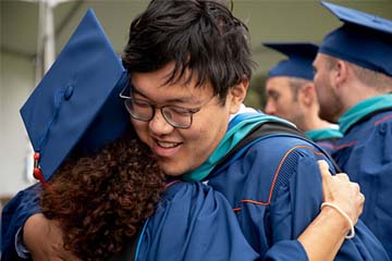 SPP graduates hugging at commencement 