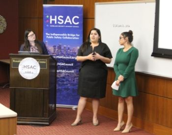 Three women standing at the front of a classroom giving a presentation