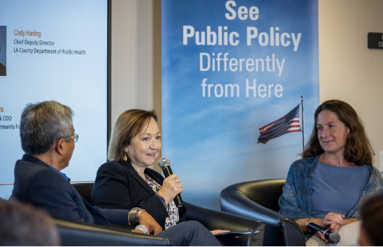 A panel of a man and two women in front of the School of Public Policy banner