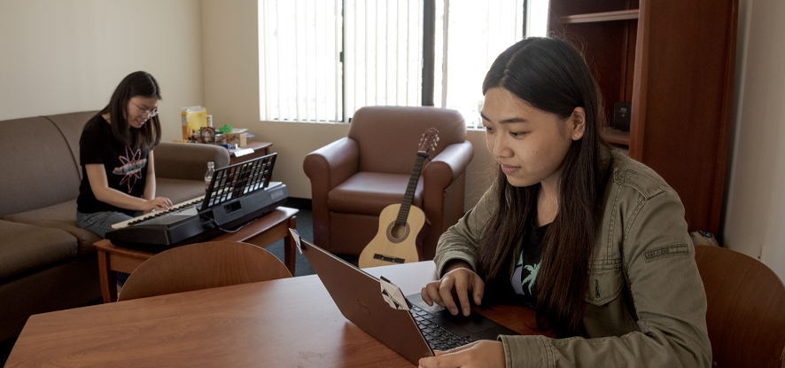 Two girls in a housing unit sitting in the living room - Pepperdine University