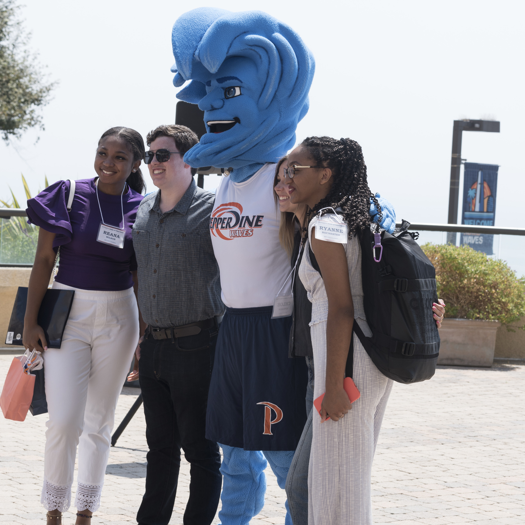 Students posing with Willy the Wave at New Student Orientation